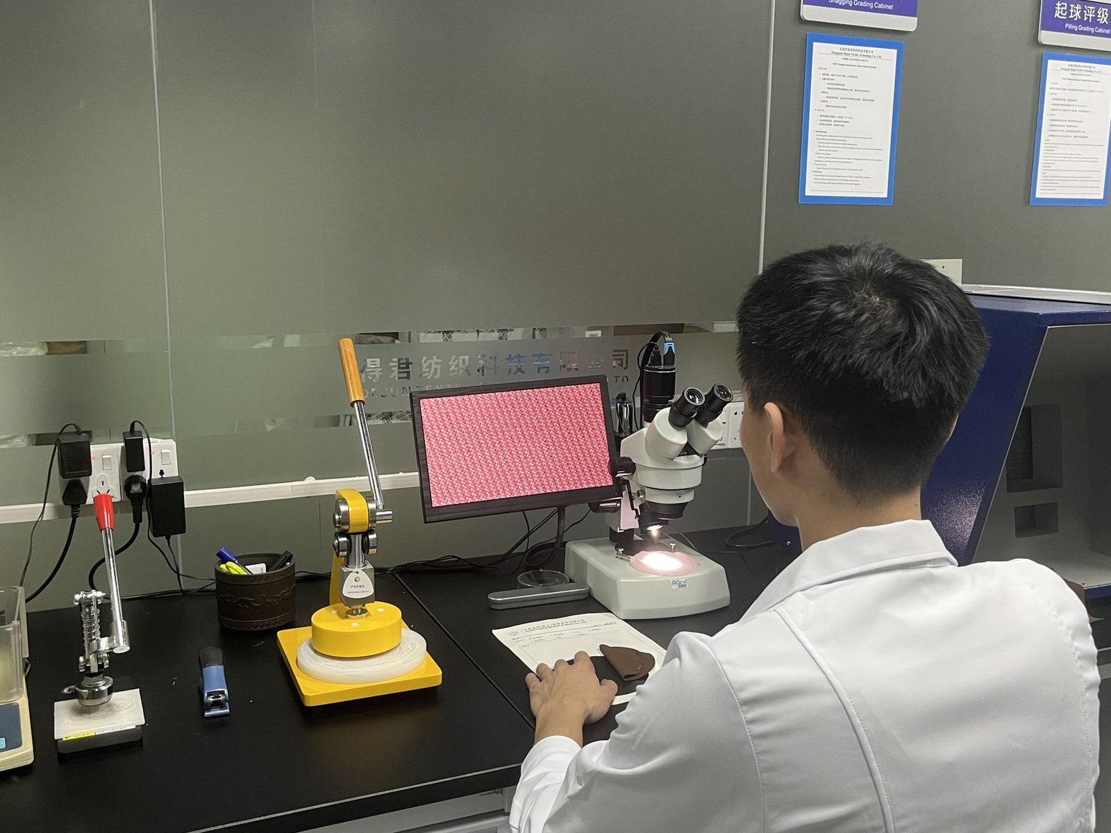 Technician examining fabric at a development workstation