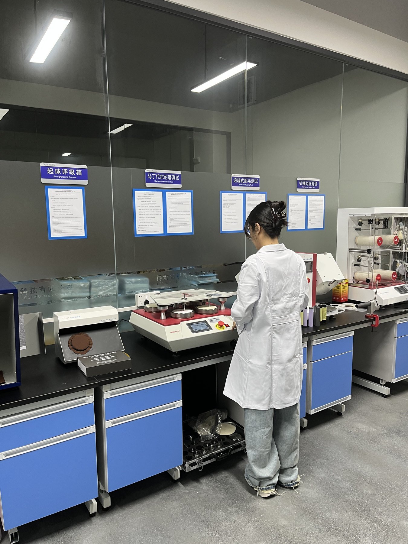 Technician using textile testing equipment in a laboratory